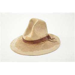 Well-worn tan Stetson cowboy hat with brown leather hat band, sweat stained, some mothing; the style