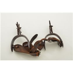 Pair of silver overlaid spurs; Mexican style with leather straps. Est.: $200-$400.