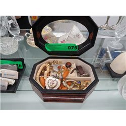 A wooden jewelry box with costume jewelry