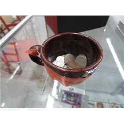 Pottery cup with assorted coins