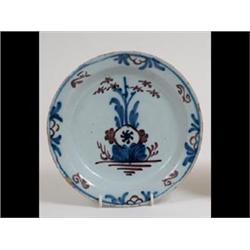 An Early 18th Century Delft Plate, the shallow bowl and rim decorated  in underglaze blue and man...