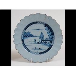 An 18th Century Delft Plate, the scalloped edge centred by a figured  fishing in underglaze blue,...