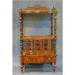 A Victorian figured walnutwood what-not Canterbury of serpentine outline, the upper section with...