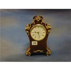 A French 8 day mantel clock contained in a shaped birds eye maple case with ormolu mounts £75-125...