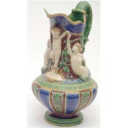 A Minton majolica jug modelled with mermaids and child, the acanthus handle with mask terminal, d...