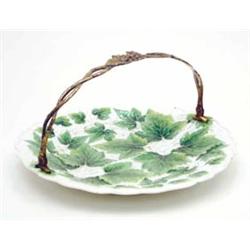 A Meissen porcelain serving dish moulded and painted with grapes and vine leaves, with ormolu swi...