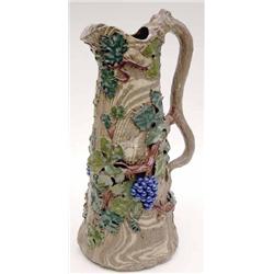 A 'solid agate' stoneware jug, probably German, moulded and enamelled with grapes and vine leaves...