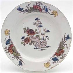 An 18th century Dutch Delft plate painted with a prunus root pattern in polychrome, 9ins (chips)...