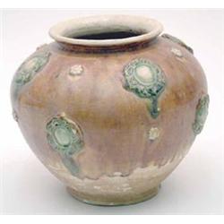An ochre and green glazed ovoid jar, the rounded sides moulded in relief with green glazed foliat...