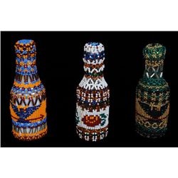 Three Nuu-chah-nulth Beaded Covered Bottles with Eagle Holding Arrow, Canoe and Floral Design 4 3/4"