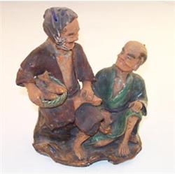 Two Japanese earthenware groups, each depicting two seated male figures, impressed character mark...