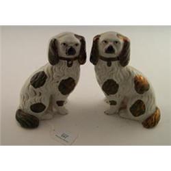 Pair of 19th Century Staffordshire comforter spaniels having open front legs, the bodies decorate...