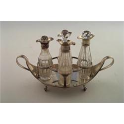 George III two handled boat shaped four division cruet stand fitted with four facet cut bottles o...