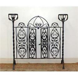 Unusual cast-iron fireplace gate. Twisted column sides support urn-shaped holder. Center section...