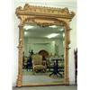 Image 1 : Large ornately framed over mantel mirror. Frame is adorned with pierce-carved scrolls, florals,...