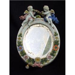 Dresden style footed mirror with putti and flowers. Note one foot is missing. $80-100...