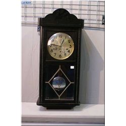 A vintage wall clock with visible pendulum