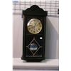 Image 1 : A vintage wall clock with visible pendulum
