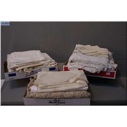 A selection of vintage table linens including large cotton, damask and lace clothes and matching nap