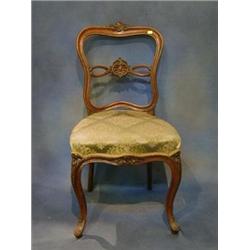 A set of 4 Victorian carved walnutwood balloon back dining chairs with carved cresting rails, pie...