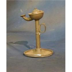 A pewter oil lamp raised on a circular base 7" £40-60...