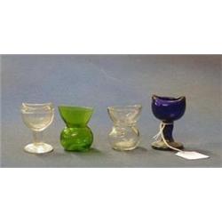 A blue glass eye bath, a green glass eye bath and 2 other £10-20...
