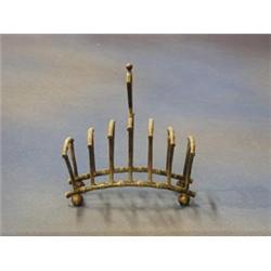 In the style of Dresser, a silver plated 7 bar toast rack with bamboo decoration and raised on bu...