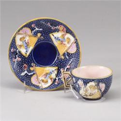 ENGLISH MAJOLICA teacup and saucer, circa 1875, with Japanese fan design on blue pebbled ground. …