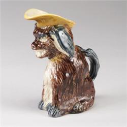 ENGLISH MAJOLICA spaniel-form jug, circa 1880, modeled as a seated spaniel with yellow cap. 6 3/4…