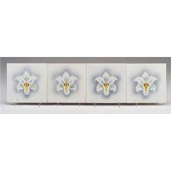 Four Belgian tiles stencil-decorated with a white cattleya orchid on a gray and white ground. A c…