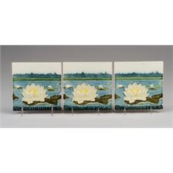 Frieze of three fine German majolica tiles, molded with ivory waterlilies and green lilypads on b…
