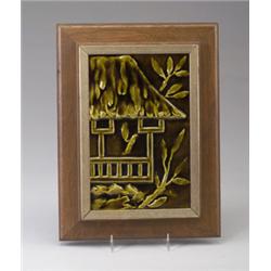 MAW tile embossed with a South Pacific hut under an olive-green glaze. Framed. Unmarked. 9" x 6".…