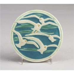 ROOKWOOD circular trivet tile, 1925, embossed with seagulls in flight over a green and blue groun…