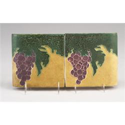 Two OWENS bullnose tiles (left and right) decorated in cuenca with a bunch a purple grapes and gr…