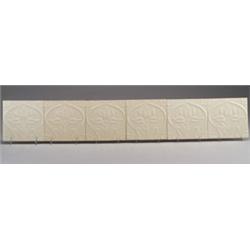 Six Belgian tiles embossed with a stylized flower, linking in a frieze, under a clear glaze. Smal…