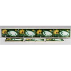 Seven German border frieze tiles with yellow flowers and green leaves on green ground. Several ni…
