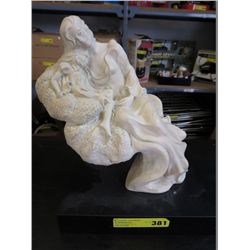 Plaster mother and child statue on a base