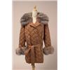 Image 1 : SATIN JACKET WITH FOX TRIM The mid-length, belted, double breasted jacket is in quilted copper co...