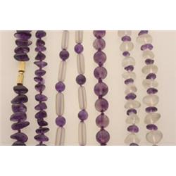 four amethyst bead necklaces The lot is comprised of: a single strand of round polished beads gra...