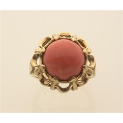 gold and coral ring In 14K yellow gold, a 12 mm. round coral cabochon is set in an eight claw pie...