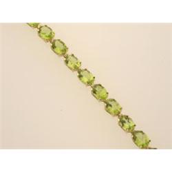 PERIDOT and gold tennis bracelet In 14K yellow gold, a straight line of twenty oval facetted peri...