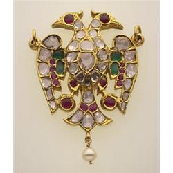 gold, diamond and gemstone figural pendant In 18K yellow gold, a stylized double headed bird pend...