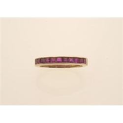 gold and ruby band style ring In 14K yellow gold, a simple band is channel set with eleven square...