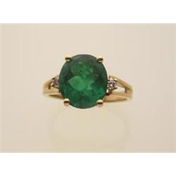 emerald, diamond and gold ring In 18K yellow gold, the four claw settings atop a split shouldered...