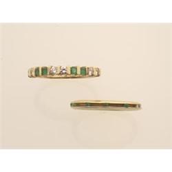 two emerald and gold rings Both rings are in 14K yellow gold. First, a narrow band is bar set wit...