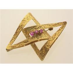 vintage gold and ruby brooch In 18K yellow gold, the brooch is designed as two engraved and textu...