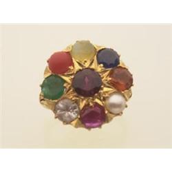 gold and gemstone ring In 18K yellow gold, a round top has a chased star shape design and is set...