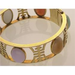 gold and multicoloured jadeite bracelet In 14K yellow gold, the round hinged bangle is set with s...