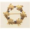 Image 1 : gold and sapphire brooch In 14K yellow gold, the brooch is designed as a wreath of six textured a...