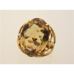 citrine and gold ring An 18K yellow gold open shouldered scrolled gallery setting contains an ova...